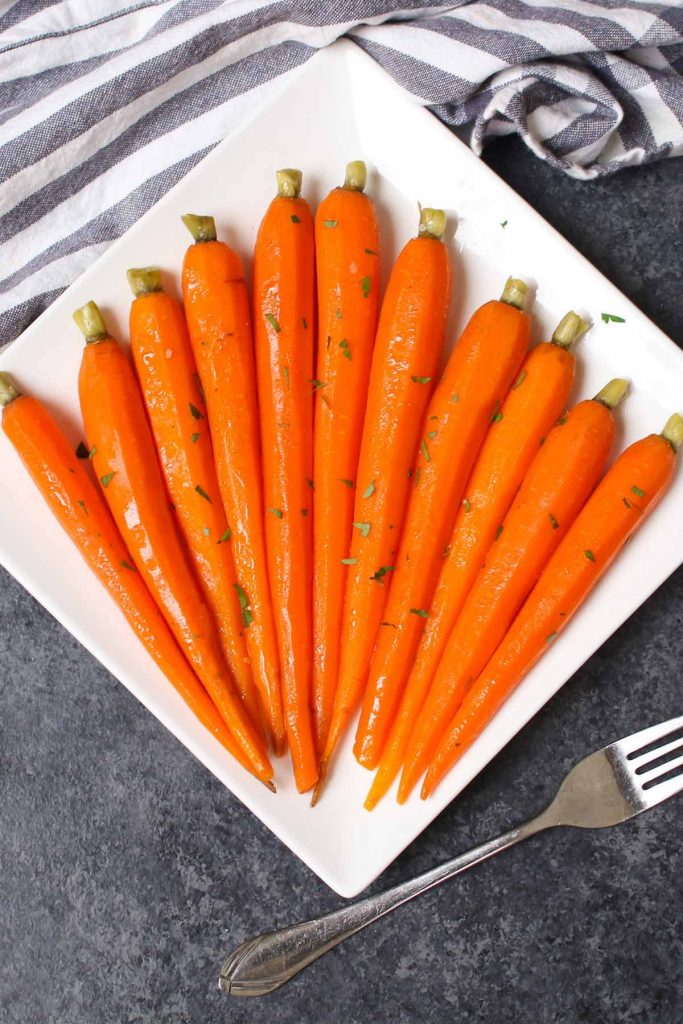 Ces carottes glacées au miel emballées sous vide sont des carottes tendres et savoureuses mijotées dans un mélange de miel et de beurre, puis garnies d'un soupçon de persil. La méthode sous vide transforme les carottes en morceaux parfaitement tendres. Sucrée, salée et pleine de saveur, cette recette est un plat d'accompagnement incroyable pour un dîner de fête ou un repas de semaine. #SousVideCarrots