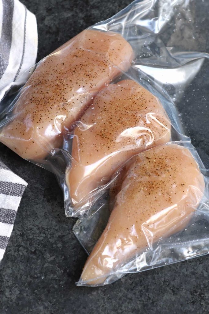 Mettre les poitrines de poulet assaisonnées sous vide dans un sac à fermeture éclair.
