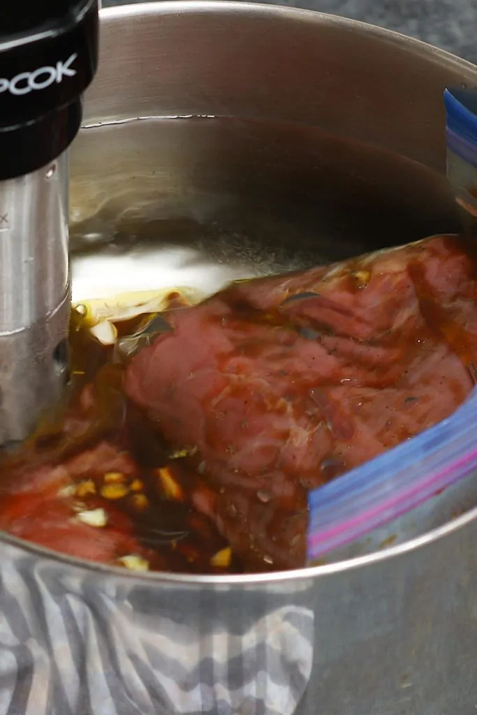 Faites cuire le steak mariné sous vide dans un bain d'eau chaude.