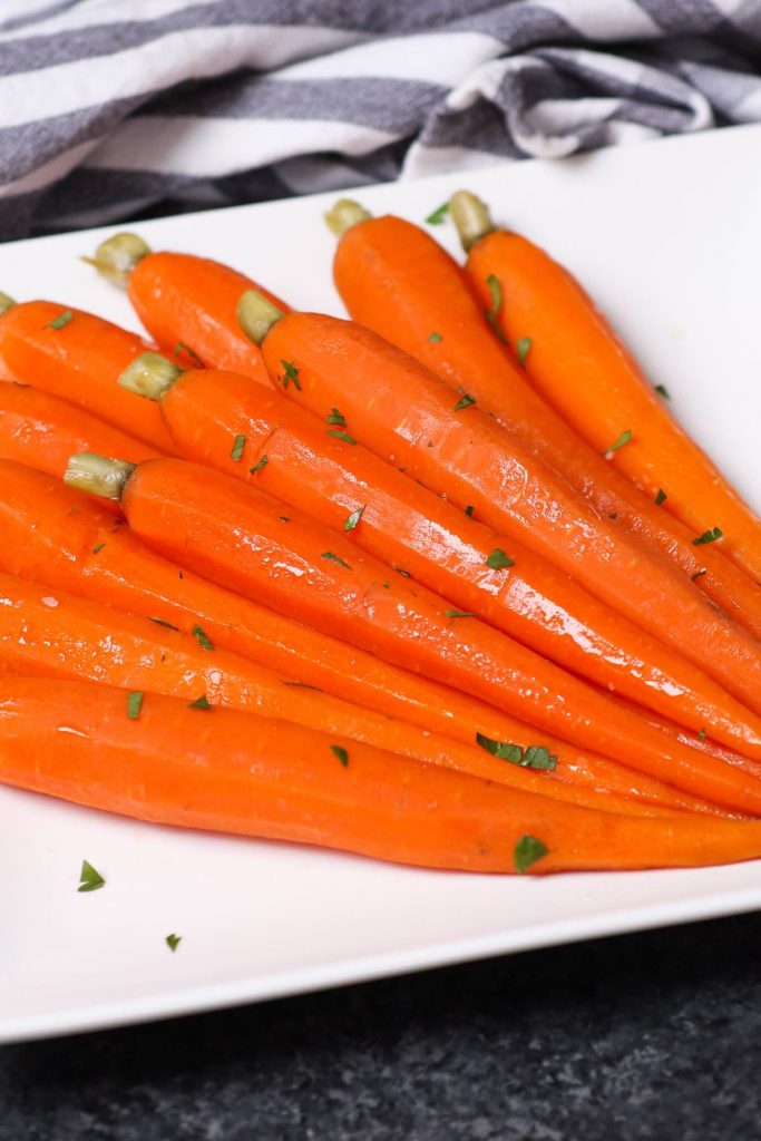 Ces carottes glacées au miel sous vide sont des carottes tendres et savoureuses mijotées dans un mélange de miel et de beurre, puis garnies d'un soupçon de persil. La méthode sous vide transforme les carottes en morceaux parfaitement tendres. Sucrée, salée et pleine de saveur, cette recette est un plat d'accompagnement incroyable pour un dîner de fête ou un repas de semaine. #SousVideCarrots